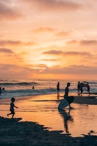 A family walks on the beach at sunset